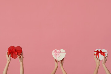 Women with gift boxes on pink background. Valentine's Day celebration