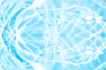 Bluewater waves on the surface ripples blurred. Defocus blurred transparent blue colored clear calm water surface texture with splash and bubbles. Water waves with shining pattern texture background.