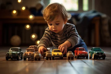 Fotobehang young caucasian baby boy plays with colorful toy cars indoors. little boy plays with toy car at home © Александр Ткачук