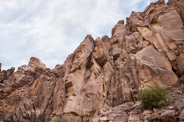 Fototapeta premium High mountains along the edges of gorge along the hiking route along the Wadi Numeira gorge in Jordan