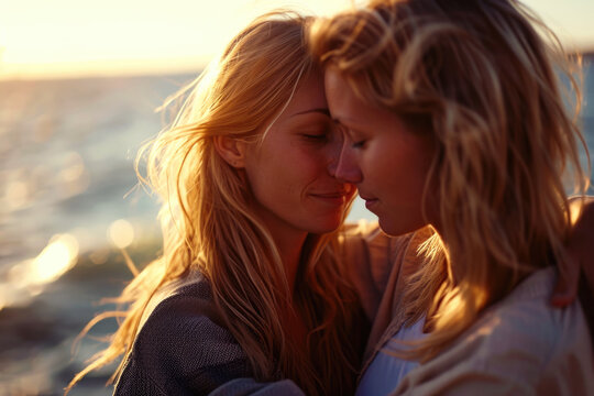 Backlit photo of Two very attractive young women kissing by the sea