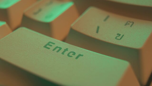 Macro shot of a man hitting enter button on a white vintage keyboard