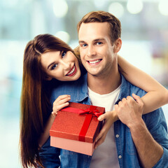 Consumer credit, celebrating, sales, rebates concept - happy smiling excited couple opening gift...