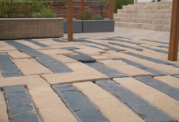 Laying gray concrete paving slabs in house courtyard driveway patio. Professional workers bricklayers are installing new tiles or slabs for driveway, sidewalk or patio on leveled sand foundation base.