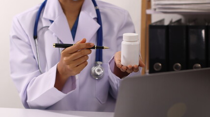 Initial AI illustration of a close-up of a female doctor's hand signing a medical document on a clipboard. and recommending certain medicines to patients on a laptop