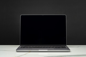 Open laptop with black screen against black background - obrazy, fototapety, plakaty
