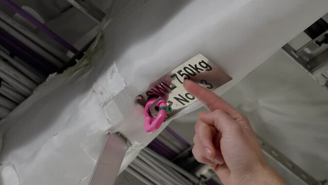 Captain inspecting ship`s lifting point in ceiling, sign marks swl 750 kg