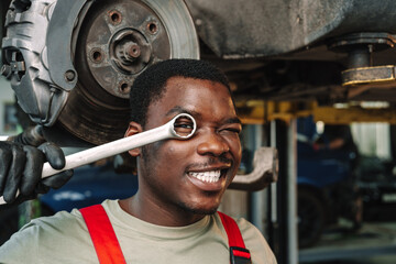 African man mechanic in uniform at the car repair station, portrait