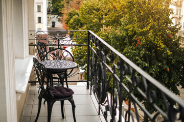 wrought iron table with chairs on the hotel balcony - obrazy, fototapety, plakaty