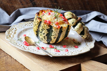Pumpkin risotto served in a hollowed pumpkin. Baked pumpkin with cheese and pomegranate seeds