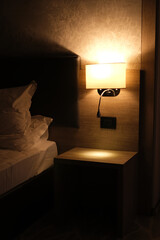 night light above the bed in a modern hotel room interior - obrazy, fototapety, plakaty