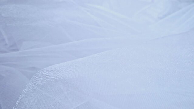 Fabric fatin white twisting as background. Textured background for atelier.
