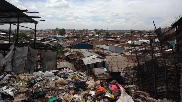 Big pile of trash and view of Kibera's tin roofs. Nairobi, Kenya