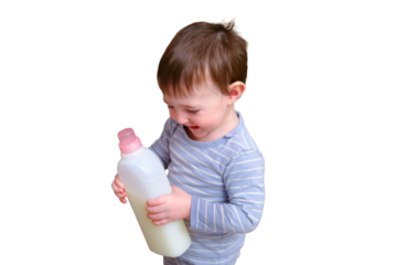 Toddler baby plays with household chemicals and detergent from the closet, isolated on white background. Child boy with detergent bottle in home living room. Kid age one year nine months