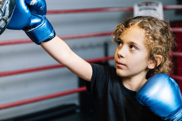 Horizontal photo elementary girl practicing boxing in the ring with her teacher. Sport concept.