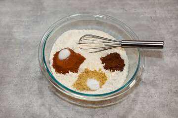 The dry ingredients for making gingerbread in a glass bowl.