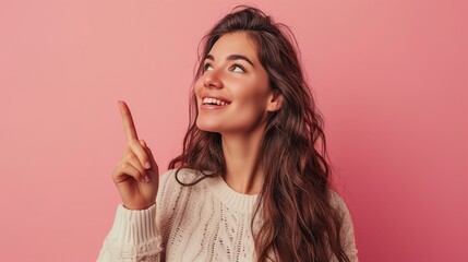 Optimistic Young Woman in Sweater Pointing Upwards on Pink Background