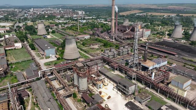 Aerial view of chemical plant. Drone shot. Billowing steam from smoke stack filling sky. Smoking chimneys from factory. Chimneys of big oil refinery polluting environment.