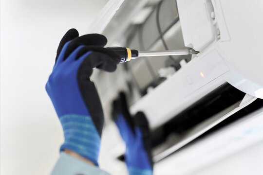 エアコンの点検をするアジア人の作業員