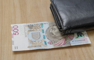 Polski banknot 500 pln leży na stole obok portfela - obrazy, fototapety, plakaty
