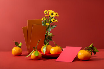 Several envelopes displayed with flowers and fresh tangerines. Chinese New Year is the longest and...