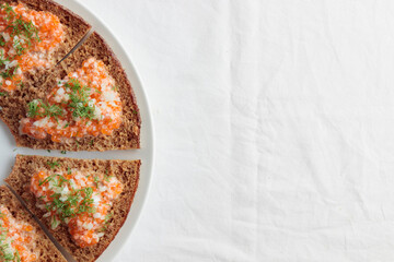 Appetizer with red caviar, sour cream, dill, onion and rye bread on the white table - the finnish recipe for a holiday food, flat lay in minimalistic style