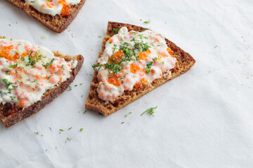 Appetizer with red caviar, sour cream, dill, onion and rye bread on the white table - the finnish recipe for a holiday food in minimalistic style