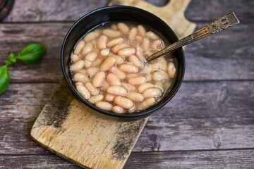   Homemade bean soup .Steamed white beans in tomato sauce  on a wooden background  