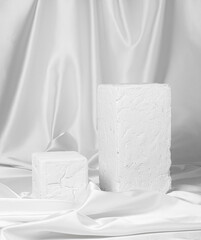 large stands made of white stone lie on a background draped with white satin
