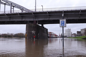 Flooding of the river Rhine, Arnhem, the Netherlands. In the background the John Frost bridge. The road is not accessible because of the high water level.