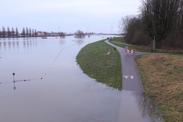 Flooding of the river Rhine, Arnhem, the Netherlands, bike path is not accessible because of the high water level. The water reaches the dike.