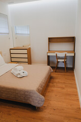 Bright room in a hotel room. Bath towels on the bed.
