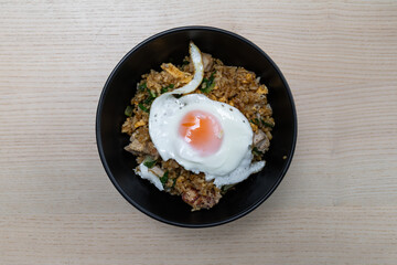 A bowl of fried rice with egg on top.