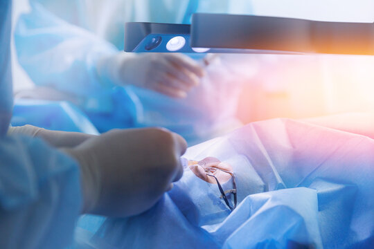 Process lasik treatment, laser vision correction. Doctor use equipment for fixing eyeball, patient under sterile cover