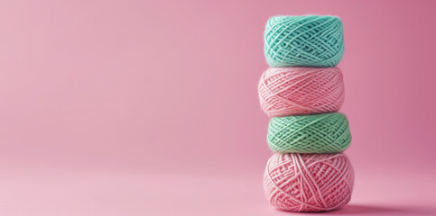 Skeins of warm woolen yarn in tangles in a delicate pastel color palette. Background for handmade and knitting store. Wallpaper with balls of yarn isolated on pink background with copy space.