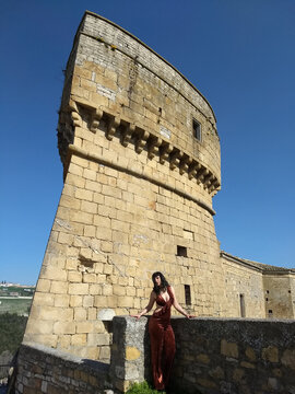 Glamour in Rocchetta Sant'Antonio: A young woman, donning daring and revealing attire, injects vitality into the stillness of the Rocca, breaking the monotony of timeless moments.
