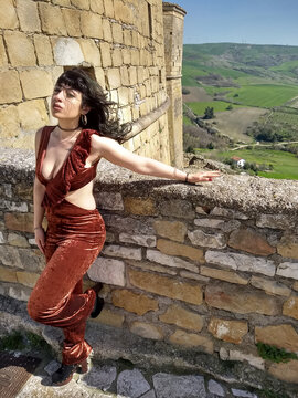Glamour in Rocchetta Sant'Antonio: A young woman, donning daring and revealing attire, injects vitality into the stillness of the Rocca, breaking the monotony of timeless moments.