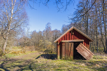 Old red shed in bad condition a sunny spring day