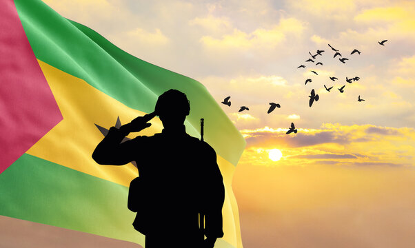 Silhouette of a soldier with the São Tomé and Príncipe flag stands against the background of a sunset or sunrise. Concept of national holidays. Commemoration Day.