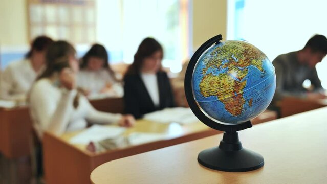 A globe of the world in a school classroom during a lesson.