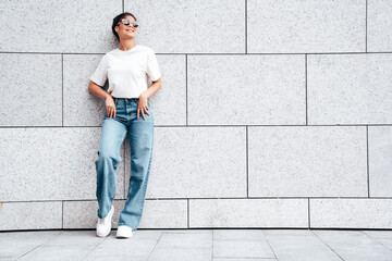 Young beautiful smiling hipster woman in trendy summer white t-shirt and jeans clothes. Carefree...