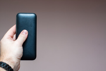 portable battery for gadgets in a man's hand