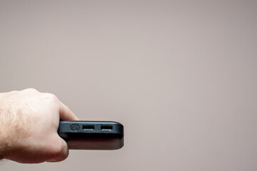 portable battery for gadgets in a man's hand