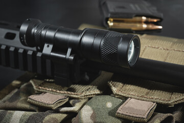 Tactical military flashlight mounted on rifles, close-up photo.