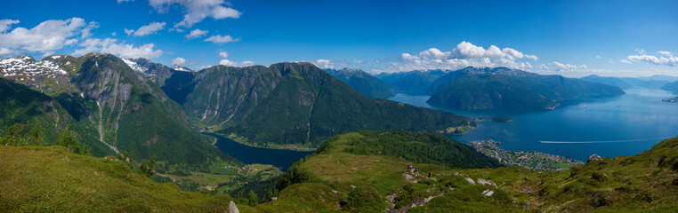 Naklejka na ściany i meble A panorama view from the summit of Raudmelen peak overlooking the town of Balestrand, Norway and Sognefjorden during a summer morning.