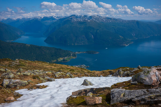 A panorama view from the summit of Raudmelen peak overlooking the town of Balestrand, Norway and Sognefjorden during a summer morning.