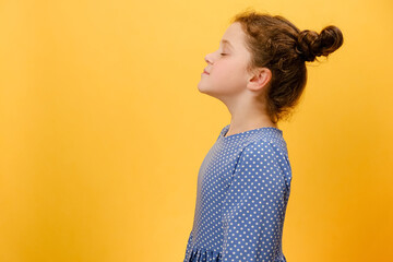 Profile side view of happy preteen girl do deep breath enjoy fresh air or dreaming fill with energy feeling healthy good concept, posing isolated over plain yellow studio background with copy space