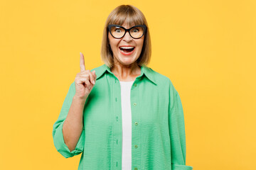 Elderly smart proactive blonde woman 50s years old wears green shirt glasses casual clothes holding...