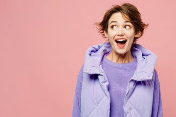 Young surprised shocked woman she wears purple vest sweatshirt casual clothes look aside on area mock up copy space isolated on plain pastel light pink background studio portrait. Lifestyle concept.
