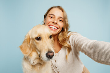 Close up young owner woman with her best friend retriever dog wearing casual clothes do selfie shot pov mobile cell phone isolated on plain pastel light blue background. Take care about pet concept.